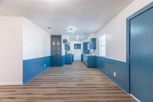 kitchen featuring light hardwood / wood-style floors, sink, and blue cabinets