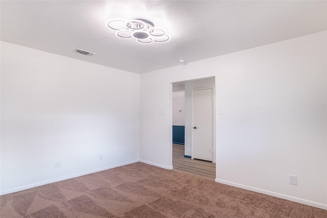 spare room featuring light carpet