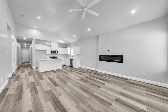 unfurnished living room featuring high vaulted ceiling, ceiling fan, and light hardwood / wood-style floors