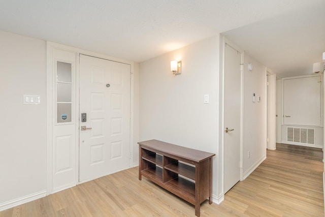 entryway with light hardwood / wood-style floors and a textured ceiling