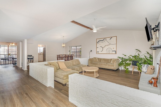 living room with ceiling fan, lofted ceiling with beams, and hardwood / wood-style flooring