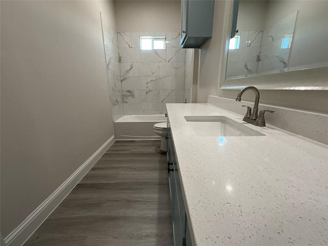 full bathroom featuring toilet, tiled shower / bath combo, hardwood / wood-style floors, and vanity