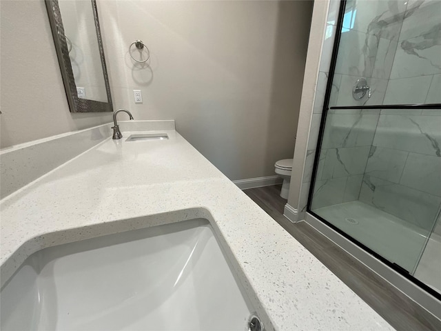 bathroom featuring vanity, toilet, hardwood / wood-style floors, and walk in shower