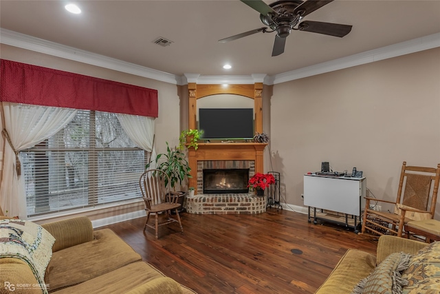 living room featuring ornamental molding, ceiling fan, a fireplace, and dark hardwood / wood-style flooring