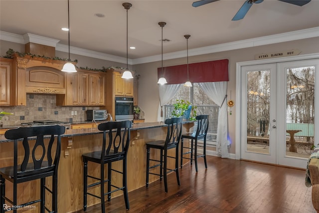 kitchen featuring dark hardwood / wood-style flooring, decorative backsplash, a kitchen bar, ornamental molding, and french doors