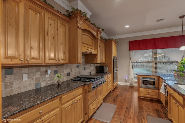 kitchen with pendant lighting, appliances with stainless steel finishes, backsplash, wood-type flooring, and ornamental molding