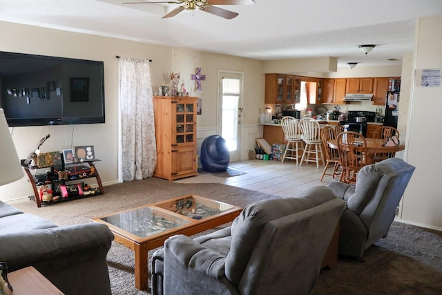 living room featuring ceiling fan and a textured ceiling