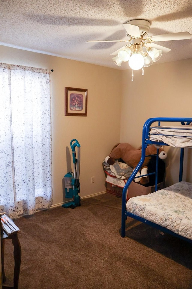 bedroom with ceiling fan, a textured ceiling, and carpet flooring