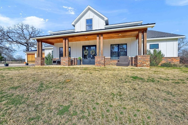 back of property with covered porch and a yard