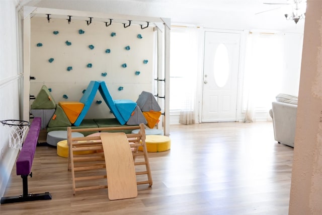 playroom featuring hardwood / wood-style flooring and a chandelier