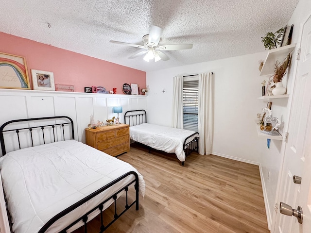 bedroom featuring ceiling fan, a textured ceiling, and light wood-type flooring