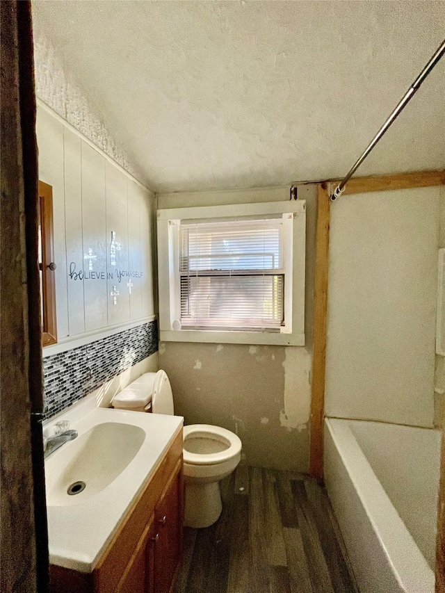 full bathroom featuring toilet, vanity, backsplash, hardwood / wood-style floors, and a textured ceiling