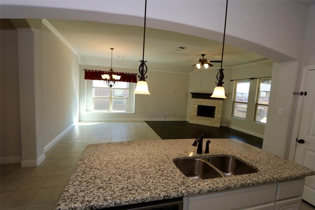 kitchen featuring white cabinets, dishwasher, an island with sink, open floor plan, and light stone countertops