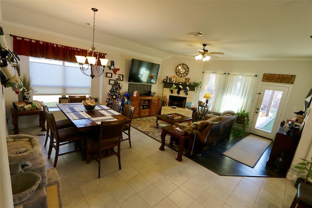 dining area featuring lofted ceiling, crown molding, a wealth of natural light, and ceiling fan with notable chandelier