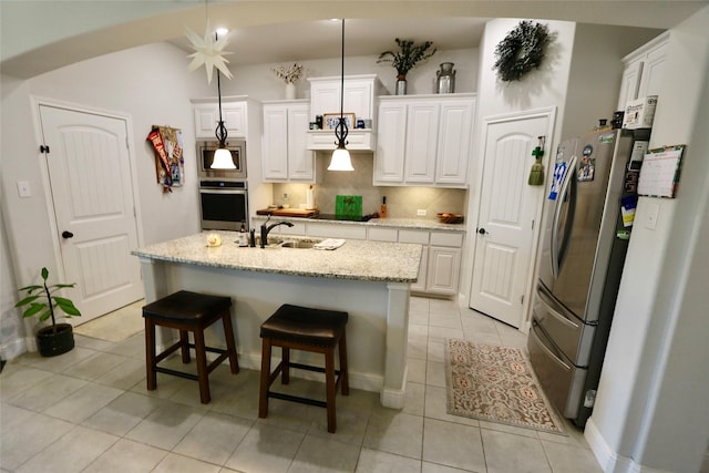 kitchen featuring a center island with sink, appliances with stainless steel finishes, and white cabinets