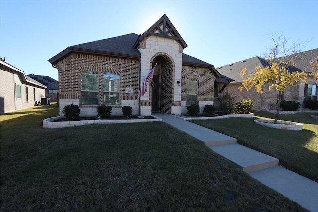 view of front of property featuring a front yard and central AC