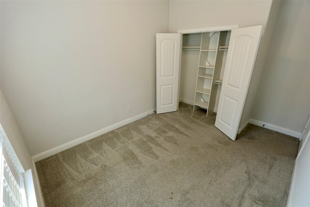 unfurnished room featuring lofted ceiling, dark carpet, and baseboards