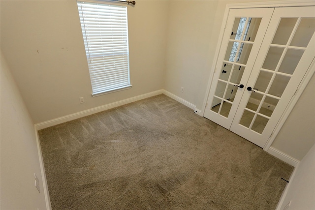 spare room featuring carpet floors, baseboards, and french doors