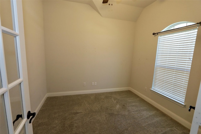 carpeted empty room with lofted ceiling, ceiling fan, and baseboards