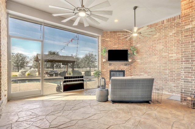 interior space with ceiling fan and an outdoor brick fireplace