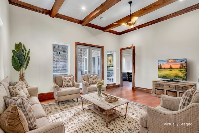 living room featuring ceiling fan, wood-type flooring, beam ceiling, and french doors