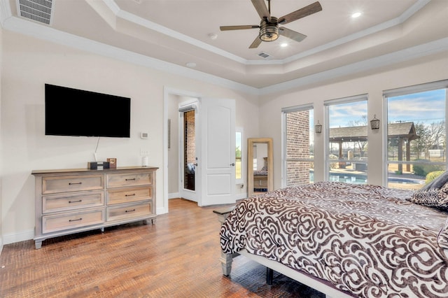 bedroom with ceiling fan, crown molding, access to outside, and a tray ceiling