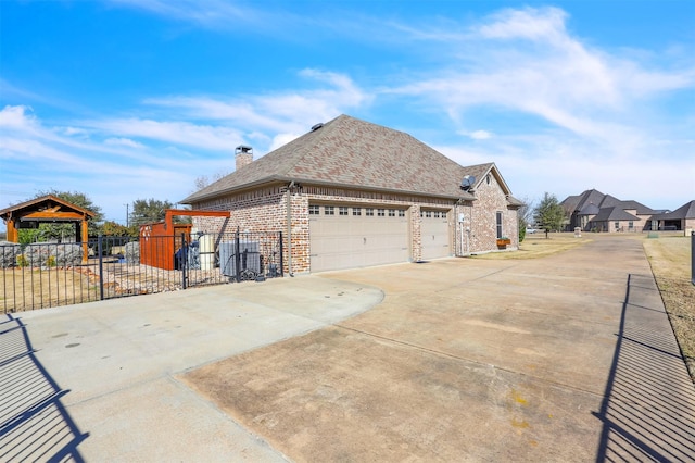 view of side of home featuring a garage and a gazebo