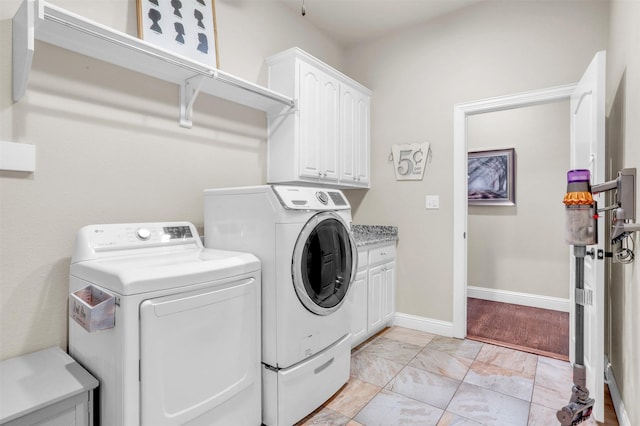 laundry room with independent washer and dryer and cabinets