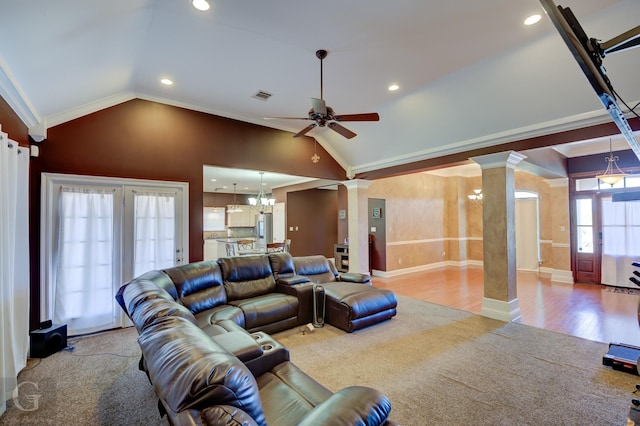 living room with lofted ceiling, hardwood / wood-style floors, crown molding, and ornate columns