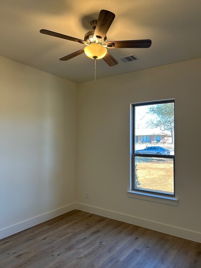 unfurnished room featuring dark wood-type flooring and ceiling fan