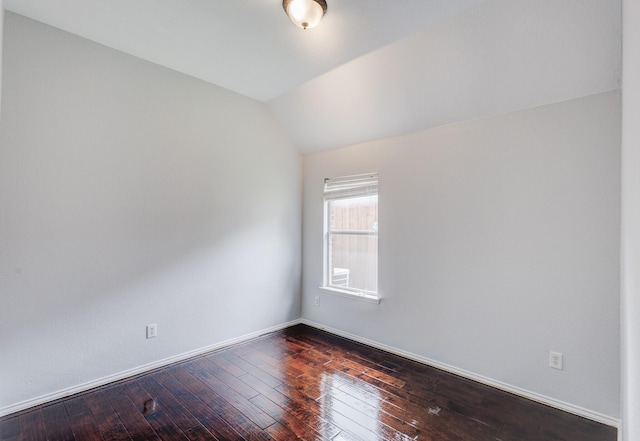 unfurnished room with dark wood-type flooring and vaulted ceiling