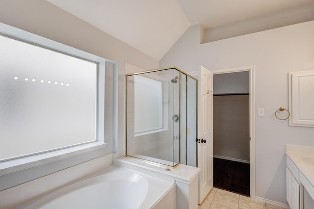 bathroom with vaulted ceiling, independent shower and bath, tile patterned flooring, and vanity