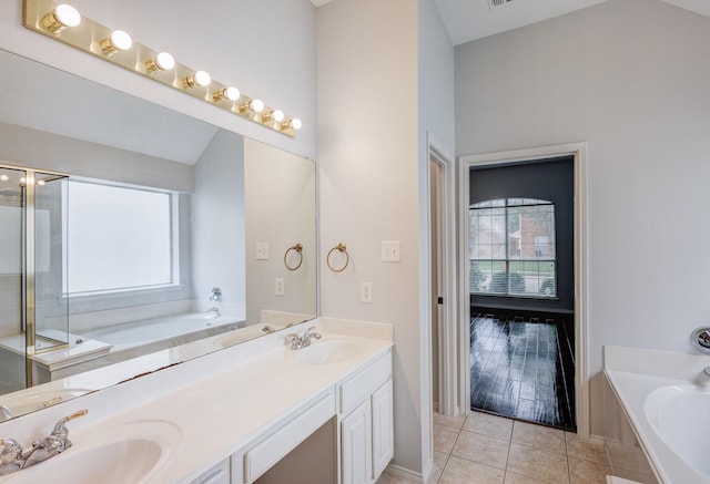 bathroom featuring a tub to relax in, vanity, and tile patterned flooring