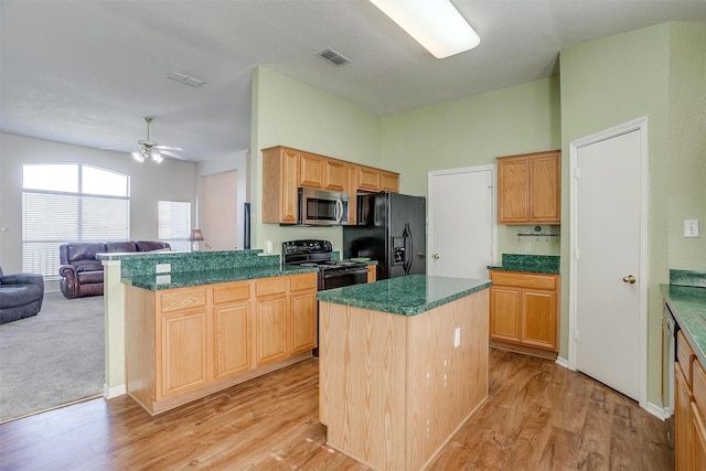 kitchen with ceiling fan, a center island, light hardwood / wood-style floors, black appliances, and kitchen peninsula