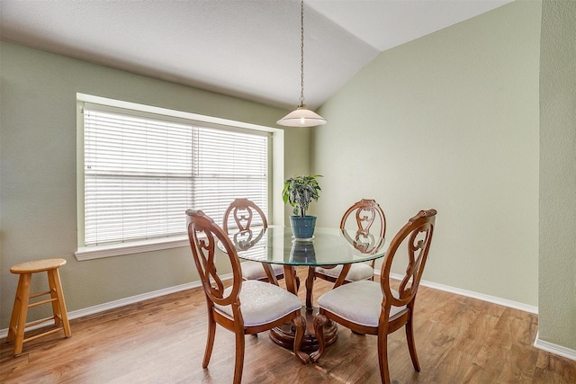 dining area with lofted ceiling and light hardwood / wood-style flooring