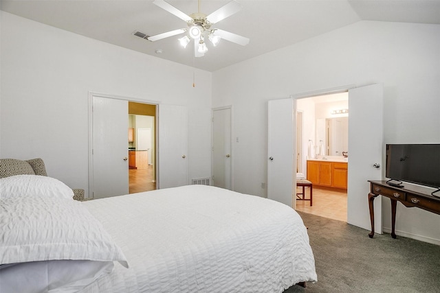 carpeted bedroom featuring connected bathroom, vaulted ceiling, and ceiling fan