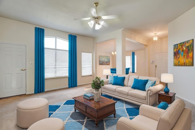 living room with light colored carpet, plenty of natural light, and ceiling fan with notable chandelier