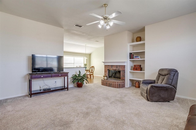 living room featuring a brick fireplace, carpet floors, and ceiling fan