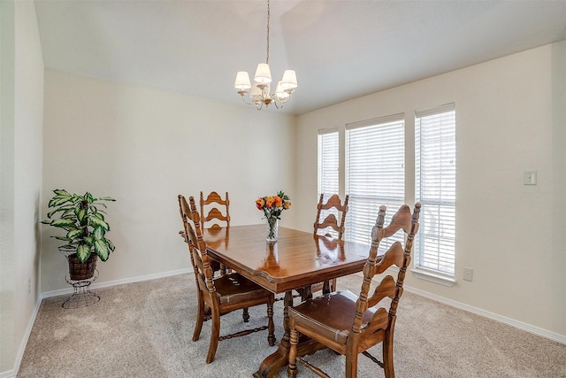 dining area featuring light colored carpet and a chandelier