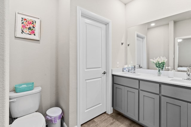 bathroom featuring hardwood / wood-style flooring, toilet, and vanity