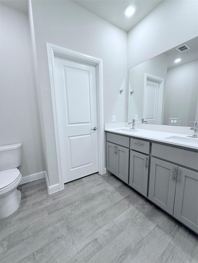 bathroom with vanity, hardwood / wood-style floors, and toilet