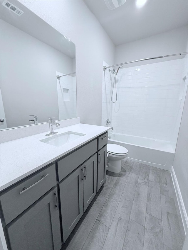 full bathroom featuring tiled shower / bath combo, vanity, wood-type flooring, and toilet