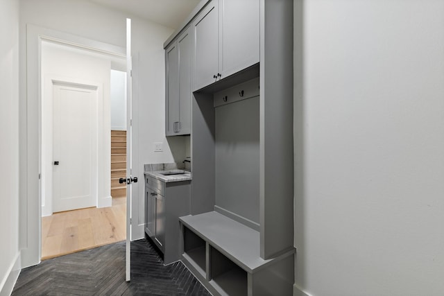 mudroom with dark parquet floors and sink