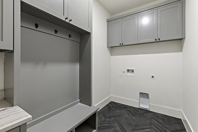 laundry area featuring hookup for an electric dryer, dark parquet flooring, hookup for a washing machine, and cabinets