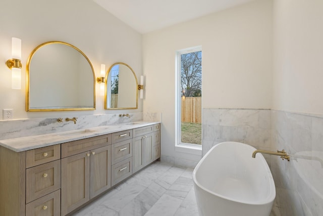 bathroom with a bathing tub, tile walls, and vanity