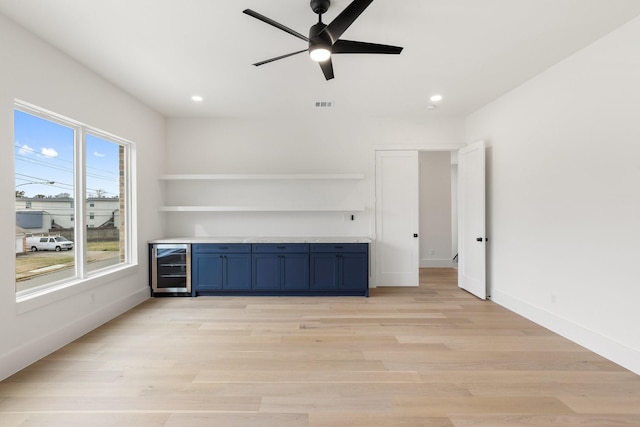 unfurnished living room with light hardwood / wood-style floors, beverage cooler, and ceiling fan