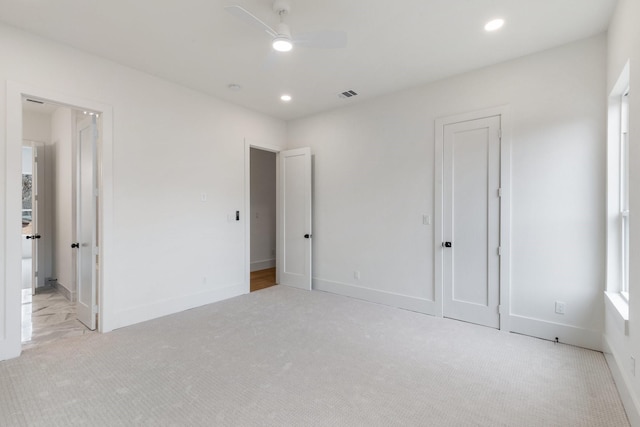 unfurnished bedroom with ceiling fan and light colored carpet