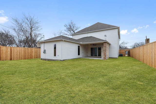 rear view of house with ceiling fan, a lawn, and a patio