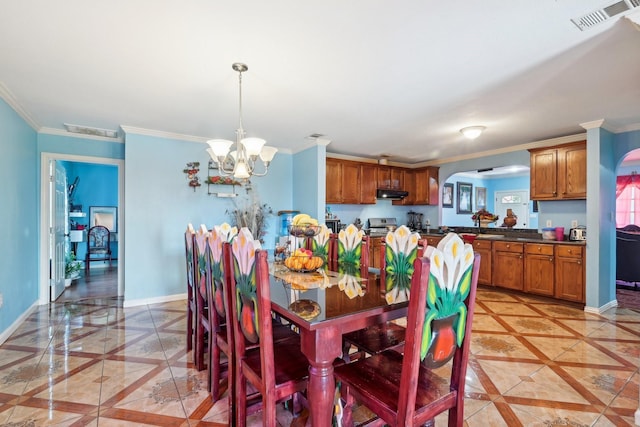 dining room with a chandelier and ornamental molding