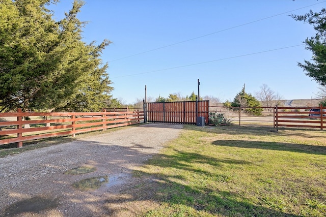 view of gate with a lawn